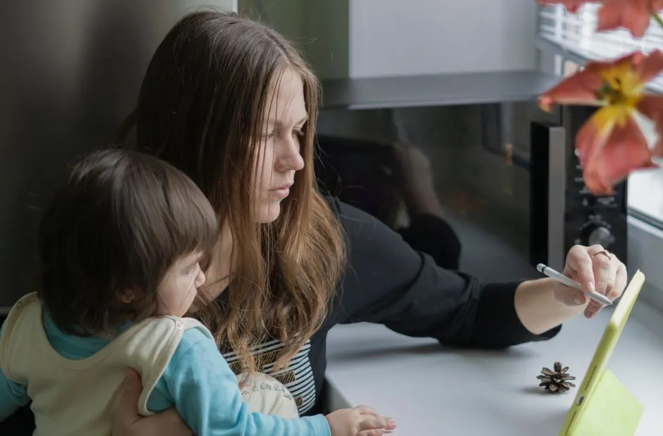A parent and toddler looking at a tablet screen together