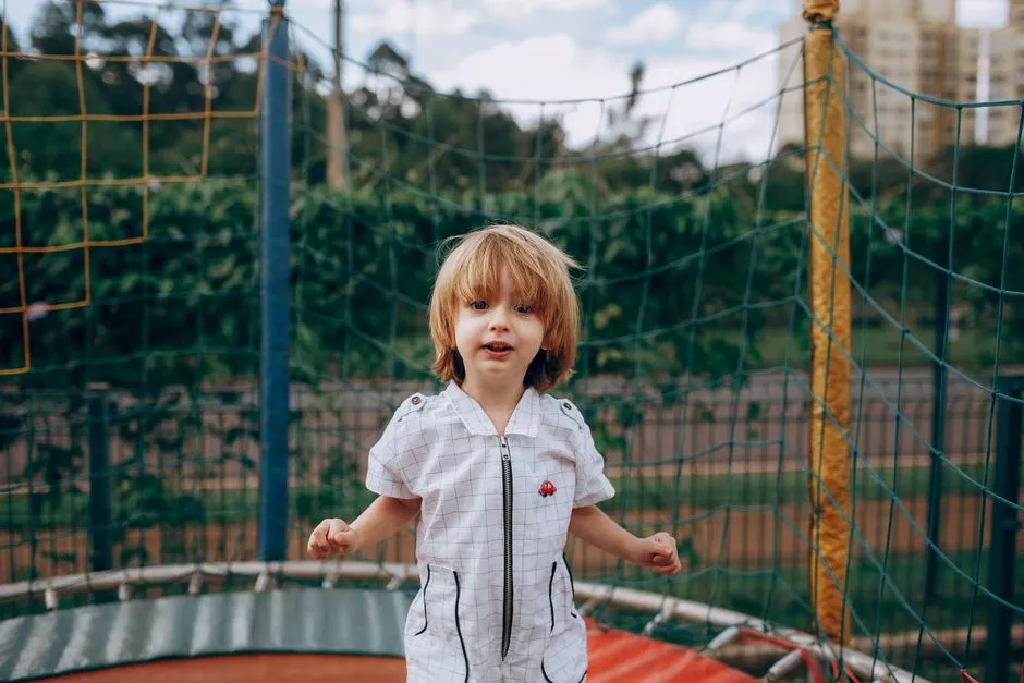 A child playing outdoors at a playground, away from a screen